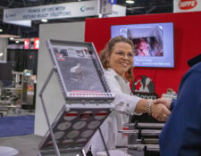 President of DeLong's, Mary Murry shaking hands with an IPPE attendee at our booth.